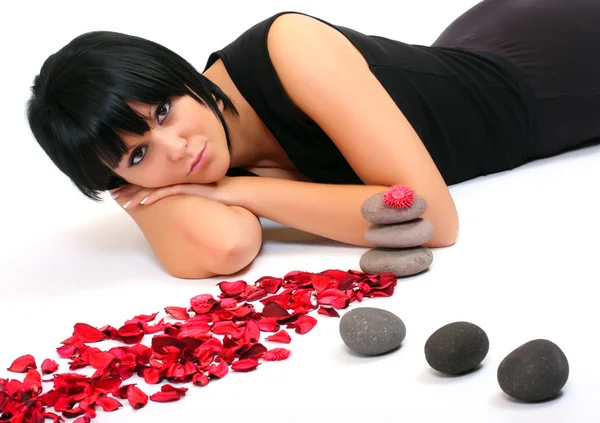 Woman with petals and stones — Stock Photo, Image