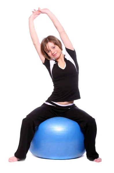 Tiro de uma jovem esportiva com bola pilates azul no fundo branco . — Fotografia de Stock