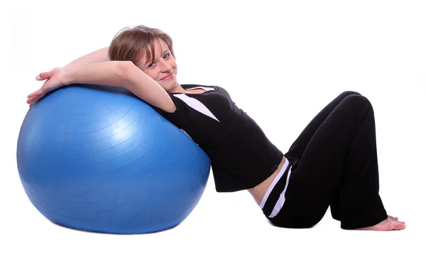 Shot van een sportieve jonge vrouw met blauwe pilates bal op witte achtergrond. — Stockfoto