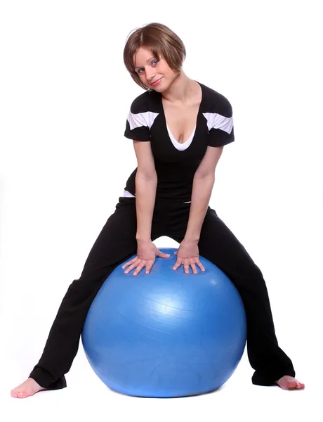 Tiro de uma jovem esportiva com bola pilates azul no fundo branco . — Fotografia de Stock