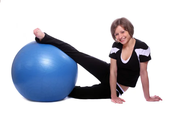 Tiro de uma jovem esportiva com bola pilates azul no fundo branco . — Fotografia de Stock