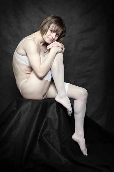 Флиртующая девушка с длинными худыми ногами в белых чулках. Винтажный стиль сдержанной фотографии . — стоковое фото
