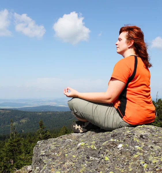 Young woman meditating on a high peak. — Stock Photo, Image