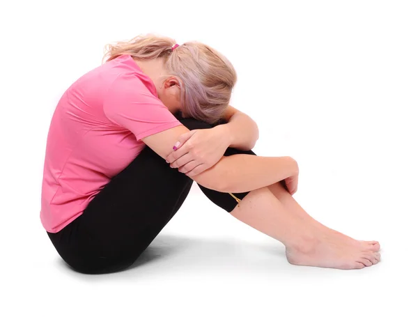 Frustrierte Frau sitzt auf weißem Hintergrund. — Stockfoto