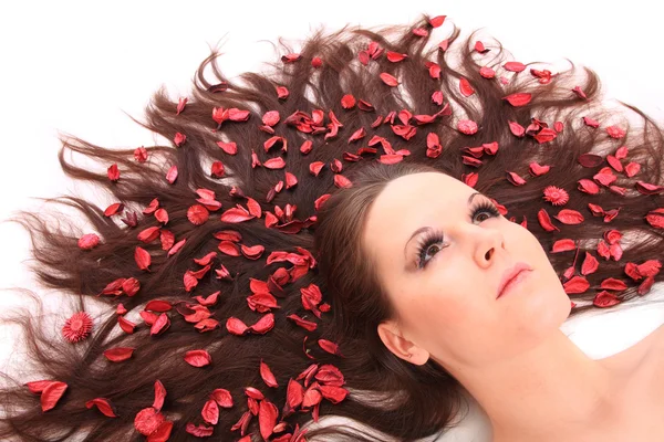 Mooie jonge vrouw met bloemen op haar lange haren. — Stockfoto