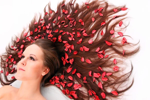 Piękna młoda kobieta z kwiatami na jej długie włosy. — Zdjęcie stockowe