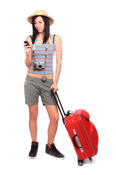 Молодая женщина собирается в отпуск с камерой и чемоданом . — стоковое фото