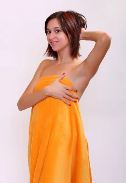 Beautiful woman going to spa with towel on light grey background - studio shot — Stock Photo, Image