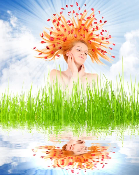 Hermosa mujer con flores en su pelo largo en hierba fresca de primavera . — Foto de Stock