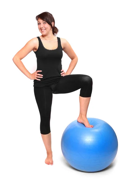 Aufnahme einer sportlichen jungen Frau mit blauem Ball auf weißem Hintergrund. — Stockfoto
