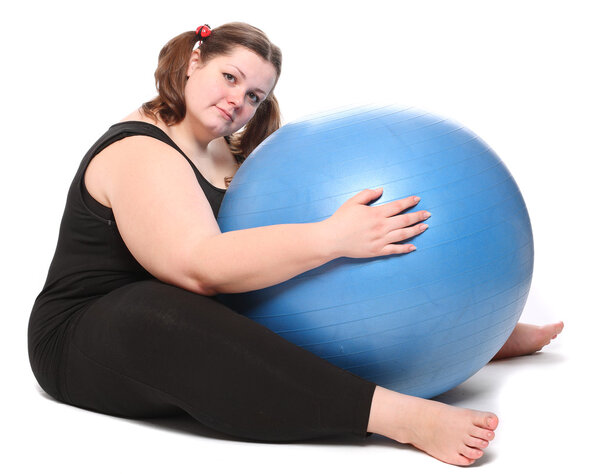 Съемка счастливой толстой молодой женщины с голубым мячом на белом фоне. Стоковое Изображение