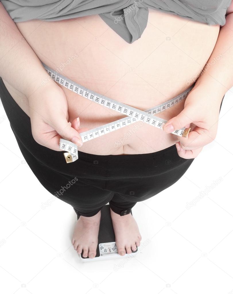 Overweight woman measure her waist