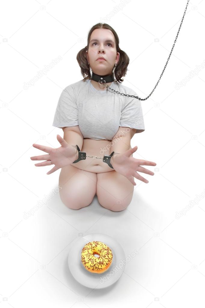 Hungry obese woman chained near plate with sweet donut. Diet theme.