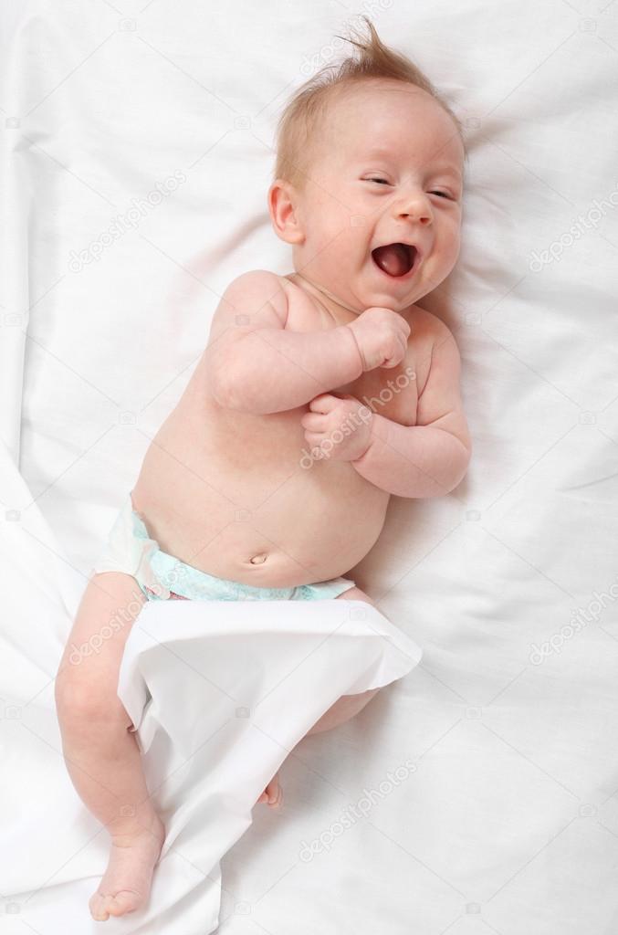 Funny baby lying on the bed.