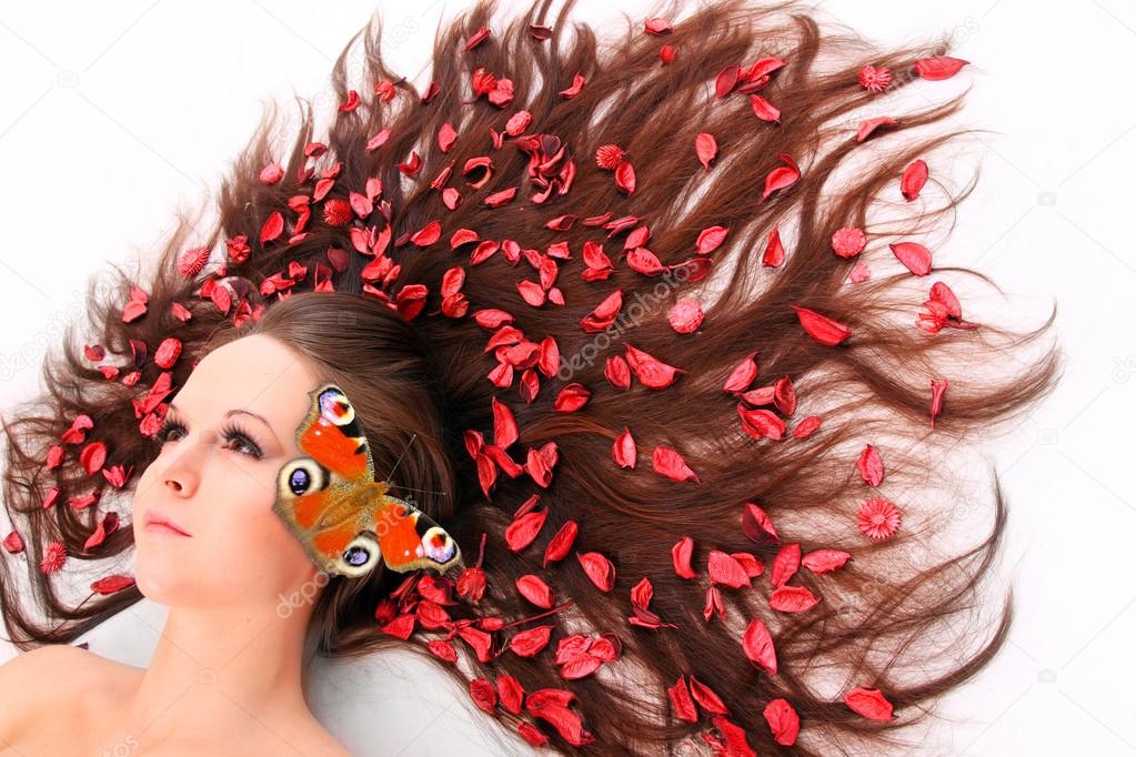 Beautiful woman with flowers (herbs) and butterly in her long hair.