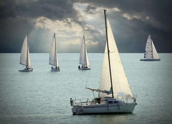 Le barche a vela su un mare contro un cielo drammatico. Immagine in stile retrò . — Foto Stock