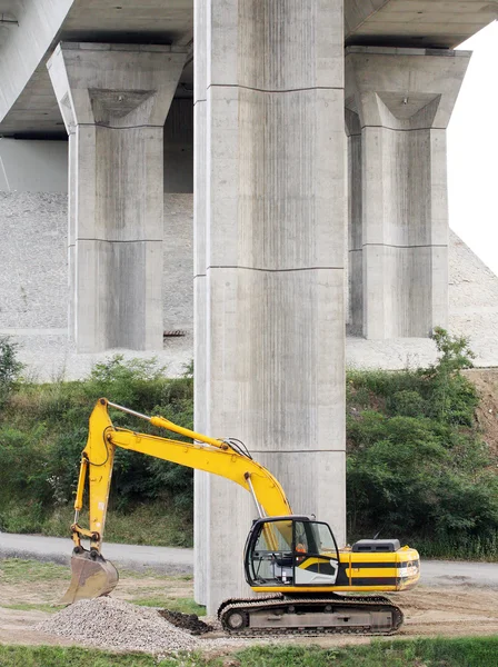 Yellow excavator on a bridge-work — Stock Photo, Image