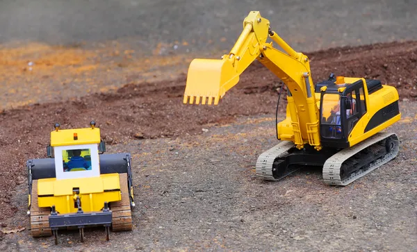 Yellow excavator on a road building — Stock Photo, Image