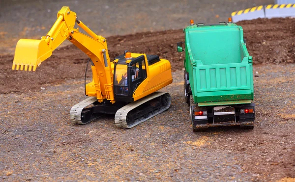 Green dumper and yellow excavator on a road building — Stock Photo, Image