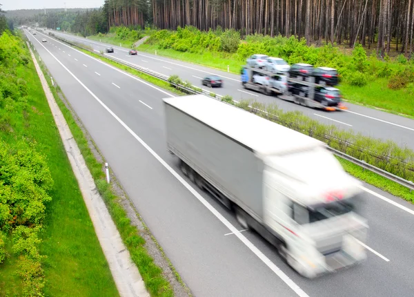 Caminhões desfocados na auto-estrada. Conceito de indústria de transporte . — Fotografia de Stock