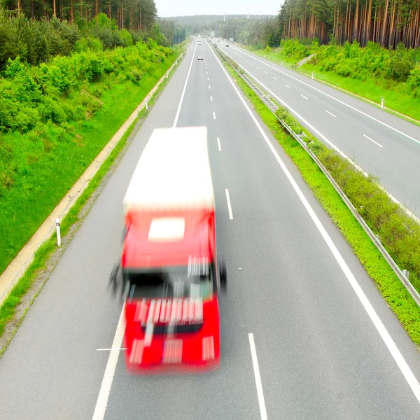 Camions flous de mouvement sur l'autoroute. Concept d'industrie des transports . — Photo