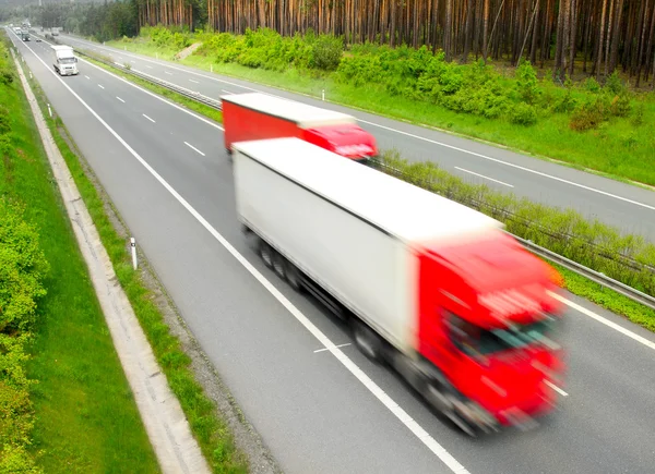 Camions flous de mouvement sur l'autoroute. Concept d'industrie des transports . — Photo