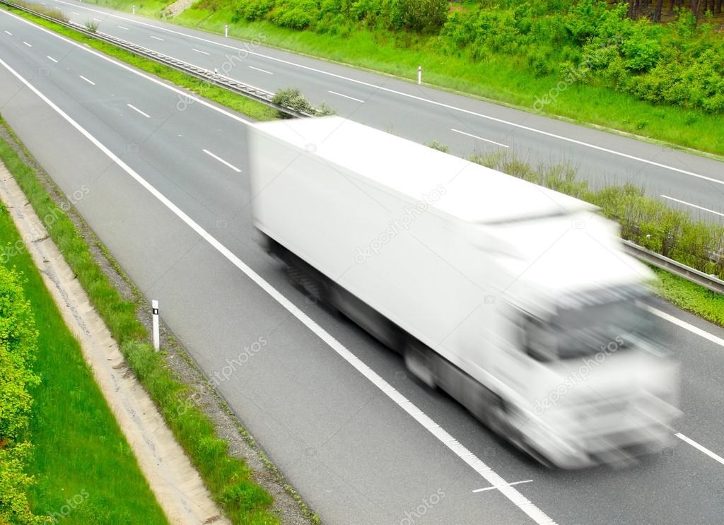Motion blurred trucks on highway. Transportation industry concept.