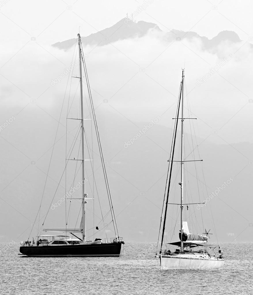 Two sail boats in early morning against Mount Capanne