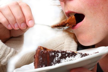 Çikolatalı pasta yiyen kız.