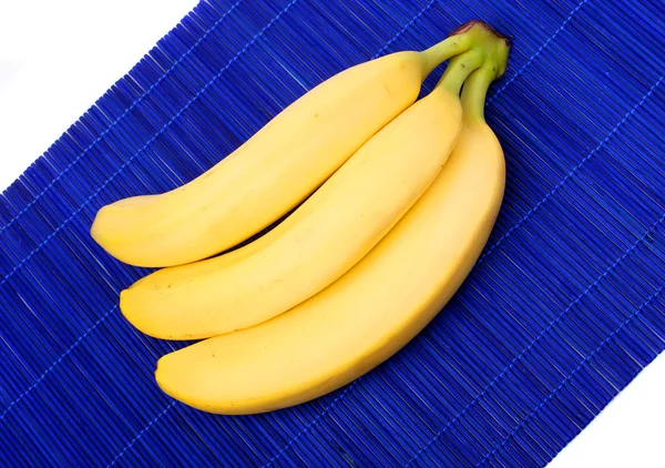 Bando de banana madura em toalha de mesa de bambu azul . — Fotografia de Stock