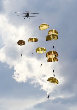 dramatik gökyüzü karşı ordu skydiver takımının Silhouettes.