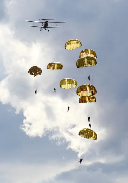Silhouetten der Fallschirmspringer-Mannschaft der Armee vor dramatischem Himmel. — Stockfoto
