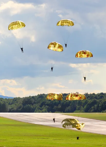 Silhouettes of the army skydiver team — Stock Photo, Image