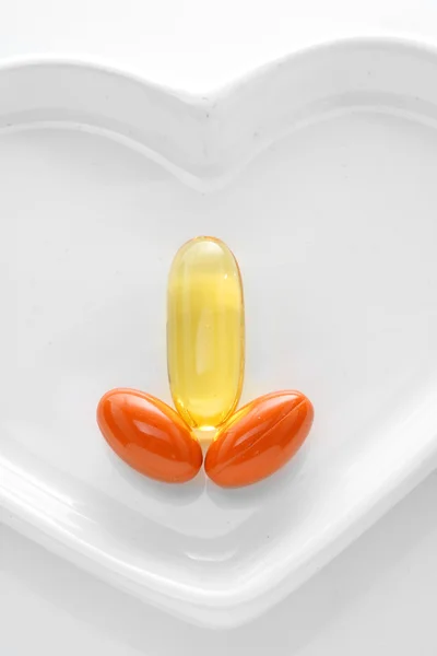 Image drôle de trois pilules colorées sur un foyer blanc . — Photo