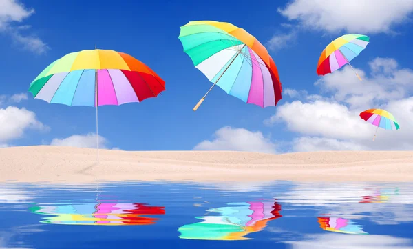 Spiaggia con ombrelloni arcobaleno in volo — Foto Stock