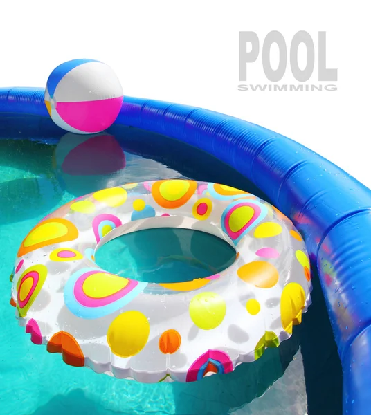 Inflatable pool with floating plastic toys. — Stock Photo, Image