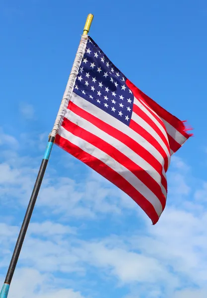 American flag waving against blue sky. — Stock Photo, Image