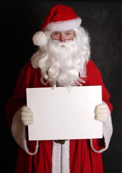 Weihnachtsmann zeigt Papier — Stockfoto