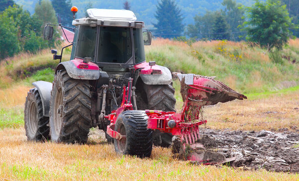 трактор вспахивает поле