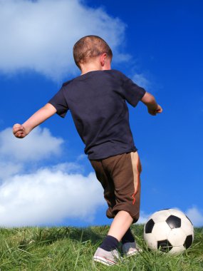 Çocuk futbol oynuyor.