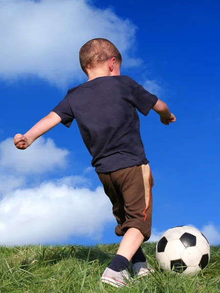 Junge spielt Fußball lizenzfreie Stockfotos