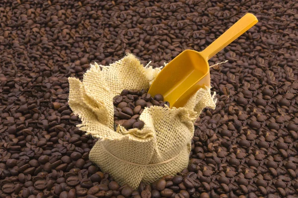 Sack Kaffeebohnen und Schaufel mit Kaffeebohnen Hintergrund — Stockfoto