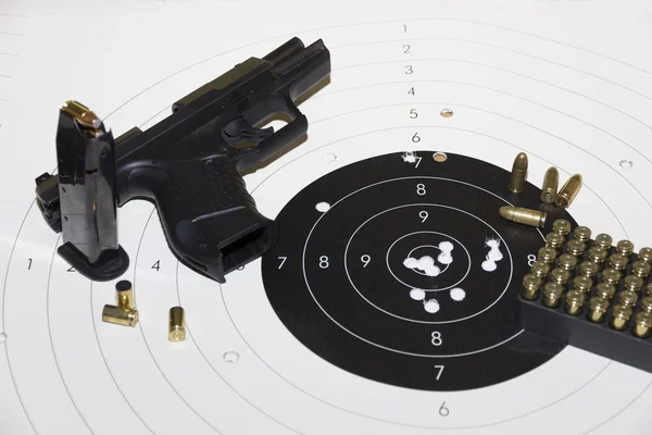 Gun and ammunition over bullseye score Royalty Free Stock Images