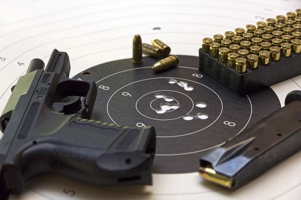 Gun and ammunition over bullseye score Stock Image