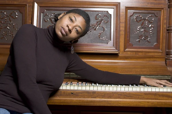 Woman in front of old piano — Stock Photo, Image