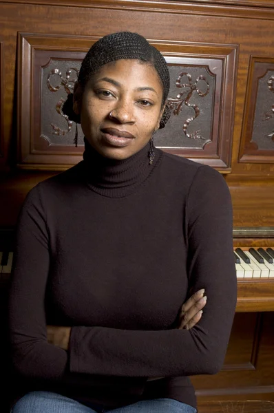 Woman in front of old piano — Stock Photo, Image