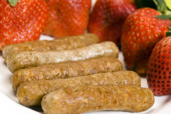 Pork sausage links with strawberries — Stock Photo, Image