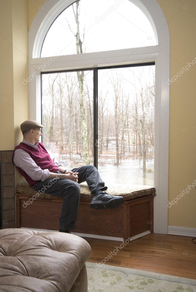 man in living room looking at flood damage