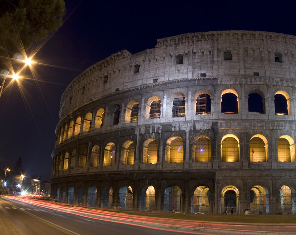 Colosseum rome italy with night light vehicle streaks tourists