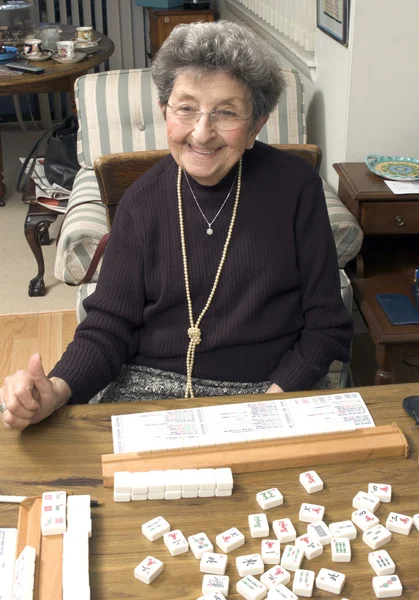 Senior woman at the game table — Stock Photo, Image